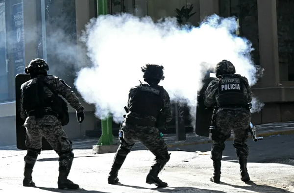 Riot police fire tear gas at miners during a march in La Paz, Bolivia