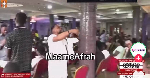 The pastor (in white) preaching to his congregation