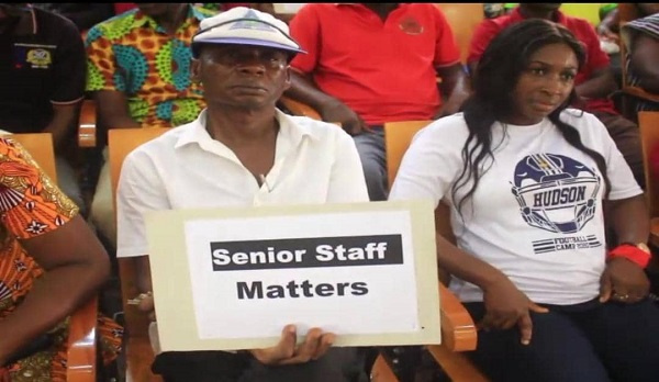 A UCC senior staff holding a placard