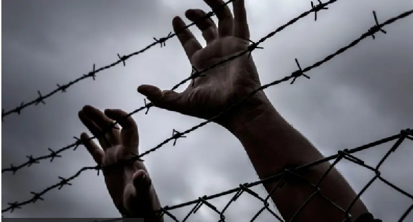 Foto wey dey show pesin hands for barbwire wey look like say e wan try to escape