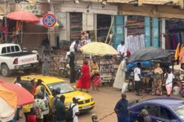 People walking down a busy street in Banjul, Gambia