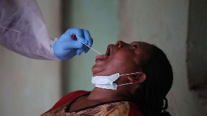 A health worker takes a swab from a woman during a community coronavirus testing campaign in Abuja