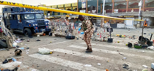 A soldier inspects the aftermath of Monday's bomb blast at a market in Maiduguri, Nigeria