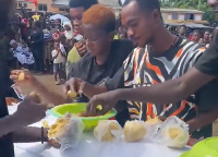Friends of deceased captured eating banku on his coffin