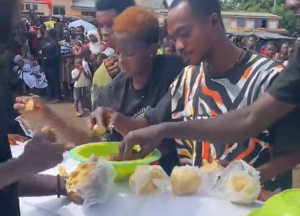 Friends of deceased captured eating banku on his coffin