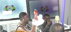 Ellen Ama Daaku displaying a red oil she claimed to have purchased for GH¢80