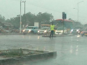 The Police officer was in the rains to direct traffic