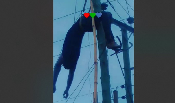 The electrocuted man hanging from the electric pole