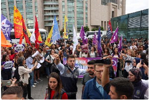 People are surrounded by plainclothes police Tuesday as they gather outside Caglayan Courthouse