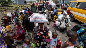 Congolese people carry their belongings as they flee from their villages around Sake in Masisi