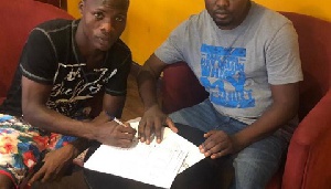 Samudeen Ibrahim signing a deal