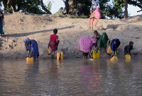 Residents move through floodwaters on a street in the town of Beledweyne
