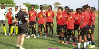 Black Queens head coach addressingg her players after a training session