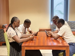 A group of people using phones at their workplace