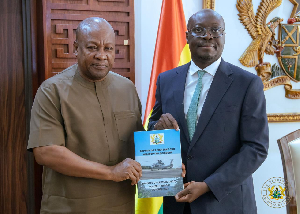 Dr Ato Forson presenting the report to President Mahama