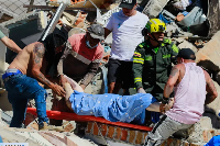 Residents and police carry a survivor pulled from the rubble after an earthquake struck Pereira