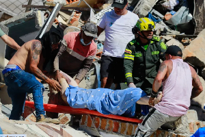 Residents and police carry a survivor pulled from the rubble after an earthquake struck Pereira