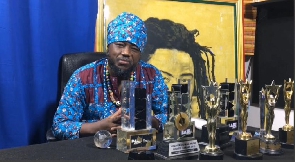 Blakk Rasta sits with all the awards he has won over the years