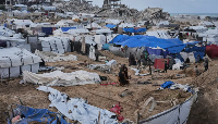 Some Palestinians inspect damaged tents following an Israeli attack in Gaza City