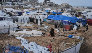 Some Palestinians inspect damaged tents following an Israeli attack in Gaza City