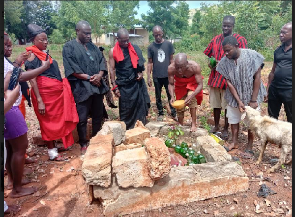 An elder pouring libation surrounded with people