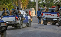 Somali police patrol near the scene of a suicide bomber attack at a cafe in Mogadishu, Somalia