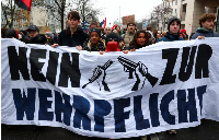 People hold a banner reading 'No to compulsory military service', during a protest in Berlin