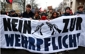 People hold a banner reading 'No to compulsory military service', during a protest in Berlin