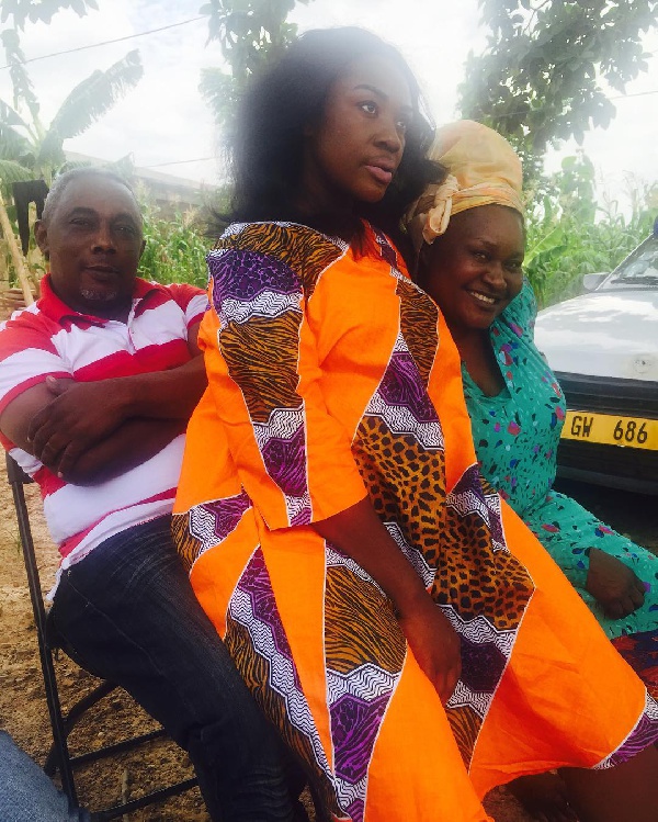 Emelia Brobbey seating on her father's lap