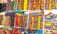 Kente is a silk and cotton fabric made of interwoven strips and is worn as a symbol of pride