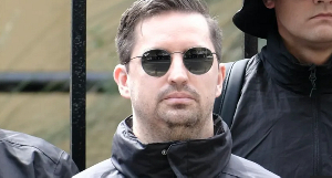 Matthew Gruter, seen among black-clad men at the protest, moved to Australia with his wife in 2022