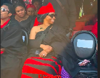 Adwoa Safo seated and smiling, with a seat saved for her brother to her left