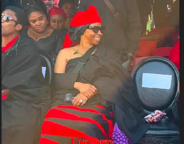 Adwoa Safo seated and smiling, with a seat saved for her brother to her left