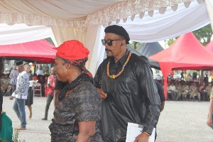 Actor Hanks Anuku in spectacles with a mourner at the funeral rites
