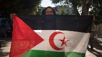 A man poses with a Western Saharan flag as he takes part in a demonstration in support of the Sahraw