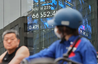 People view Japan's Nikkei stock index in Tokyo