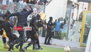 Referee Ernest Baafi had to be shielded