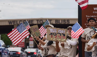 Protesters opposing mass deportations by ICE hold signs during a protest