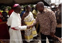 President John Mahama exchange greetings with a priest