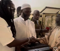 Prince Tagoe (L) handing an item to a representative of Madina mosque