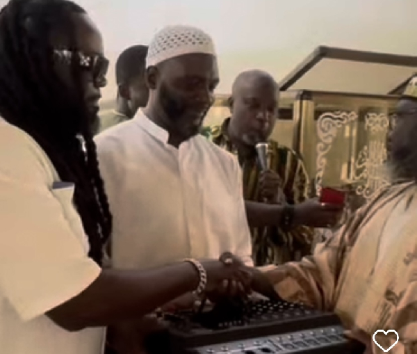 Prince Tagoe (L) handing an item to a representative of Madina mosque