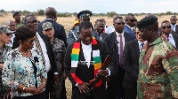 President Mnangagwa (with scarf) checks out a rifle