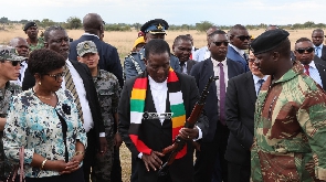 President Mnangagwa (with scarf) checks out a rifle