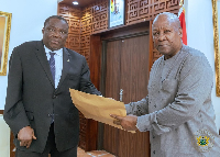 Chairman of the committee, Justice Pwamang presenting the report to President Mahama