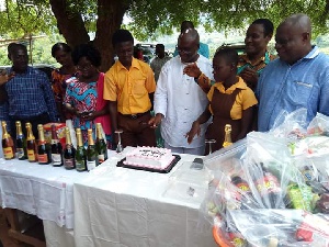 Paul Asare Ansah with students, teachers behind the cake