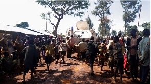 Congolese children run after a UN armoured personnel carrier at Rhoe IDP camp in Djugu