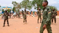 Soldiers stand guard as supporters gather for a demonstration in Niamey near a French airbase