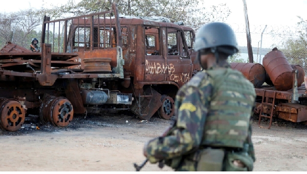 A security forces soldier walks past a burned truck at the port of Mocimboa da Praia