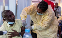 A Congolese health official administers an mpox vaccination to a man