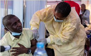 A Congolese health official administers an mpox vaccination to a man